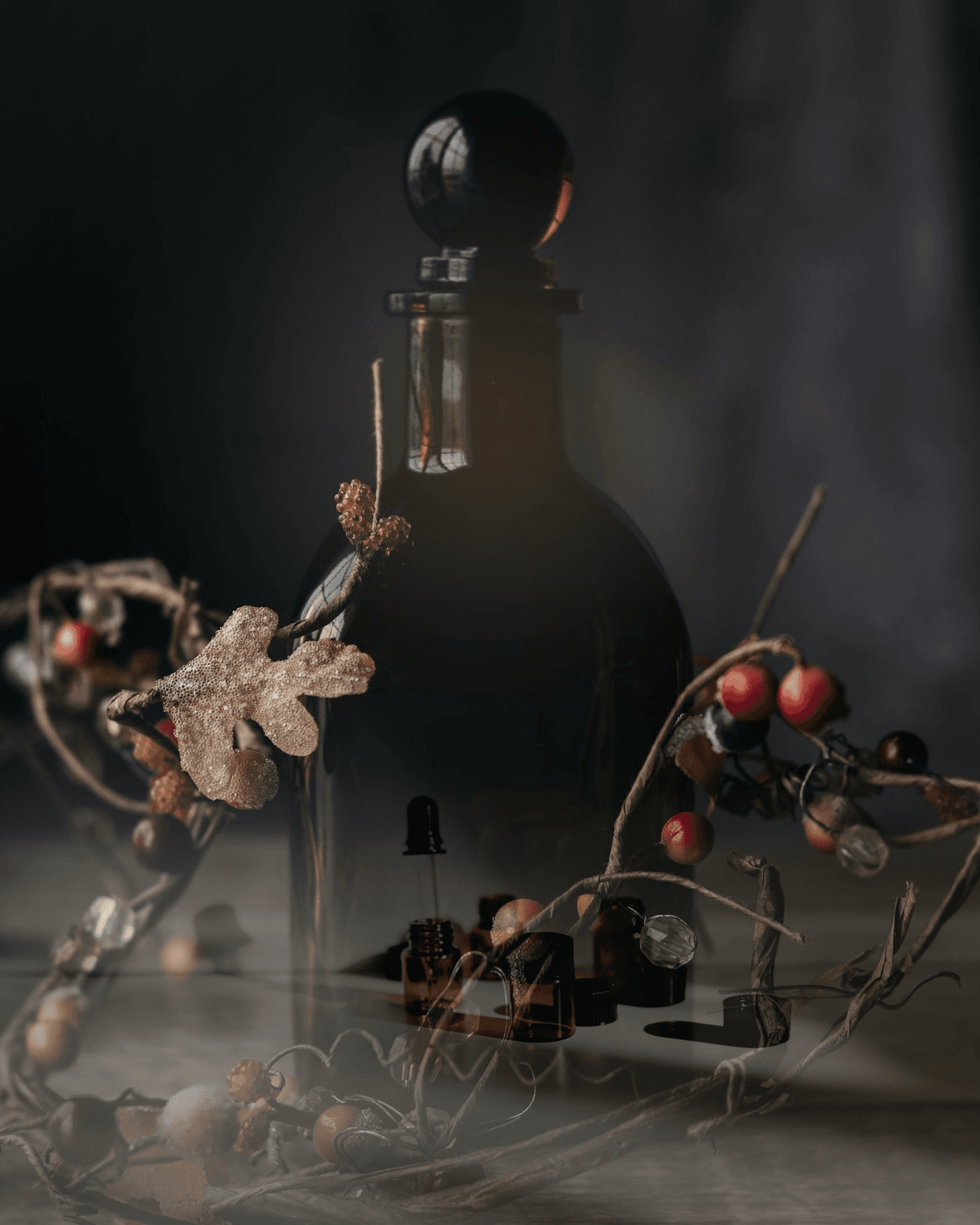 چیدمان مفهومی بطری عطر، ویالهای رایحه و مواد گیاهی
